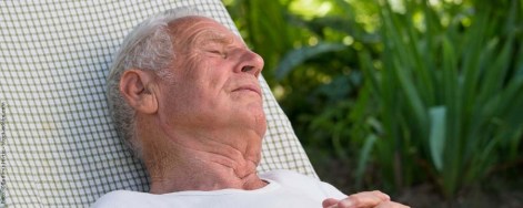 Älterer Mann schläft im Garten