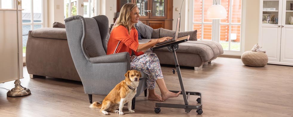 Frau im Homeoffice auf Sessel mit Beistelltisch