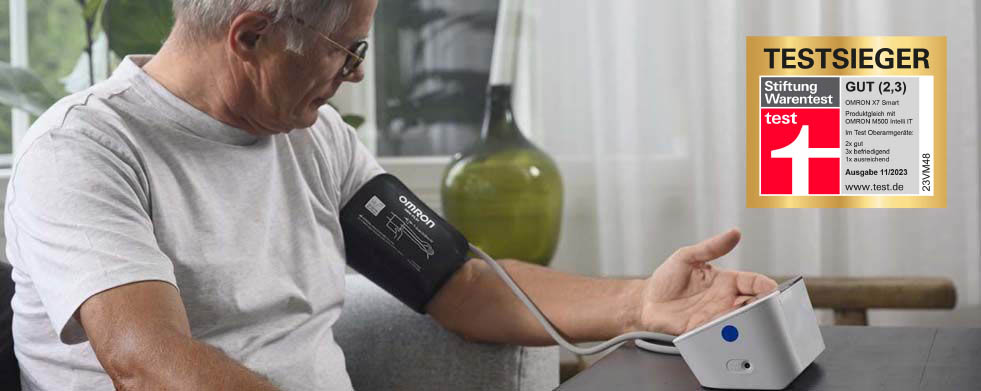 Mann mit Brille misst Blutdruck mit OMRON M500 Intelli IT