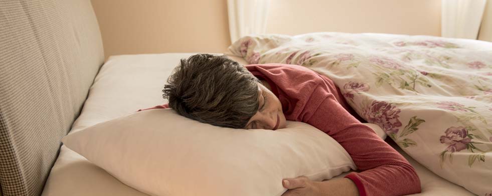 Frau mit Elsa Flockenkissen im Bett